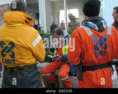 Rene Robben (C) spricht mit seinen Kollegen aus dem Kader der Bergung eines niederländischen Bergung Unternehmens in Gigilo, Italien, 17. Januar 2012. Die italienische Reederei der Schiff Costa Crociere, Besitzer des zerstörten Kreuzfahrtschiff "Costa Concordia", hat die niederländische Bergung Firma Smit, den Kraftstoff aus dem Wrack zu entfernen eingestellt. Sie müssen warten, weil Rettungsaktionen Priorität haben. Foto: Peter Mayer Stockfoto