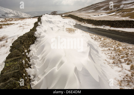 Massive Schnee driftet Block Kirkstone Pass-Straße oberhalb Ambleside im Lake District, Stockfoto