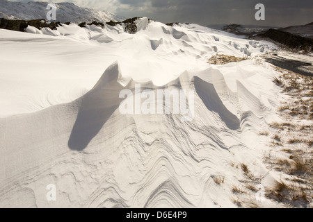 Massive Schnee driftet Block Kirkstone Pass-Straße oberhalb Ambleside im Lake District, Stockfoto