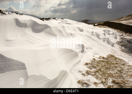 Massive Schnee driftet Block Kirkstone Pass-Straße oberhalb Ambleside im Lake District, Stockfoto