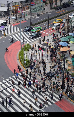 Straßenszene mit Massen von Menschen, die über die Straße auf einem Fußgängerüberweg in Harajuku, Tokyo, Japan Stockfoto