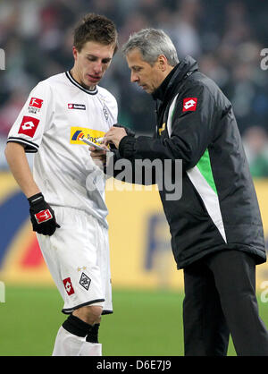 Borussia Moenchengladbach Cheftrainer Lucien Favre (R) spricht mit seinem Spieler Patrick Herrmann während der Bundesliga-Fußballspiel zwischen Borussia Moenchengladbach und FC Bayern München in Mönchengladbach, 20. Januar 2012. Foto: Roland Weihrauch Stockfoto