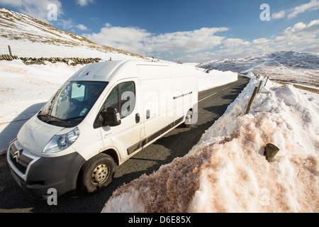 Massive Schnee driftet am Straßenrand Kirkstone Pass über Ambleside im Lake District, Stockfoto