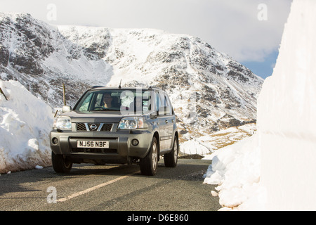 Massive Schnee driftet am Straßenrand Kirkstone Pass über Ambleside im Lake District, Stockfoto