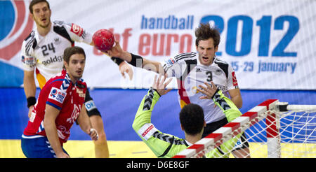 Deutschlands Uwe Gensheimer (C) in Aktion gegen Serbiens Nikola Manojlovic (L) und Torhüter Darko Stanic (R) beauftragt, dass sein Team bei Time-out in der Handball-Europameisterschaft zwischen Serbien und Deutschland in Belgrad, Serbien, 21. Januar 2012 übereinstimmen. Foto: Jens Wolf Stockfoto