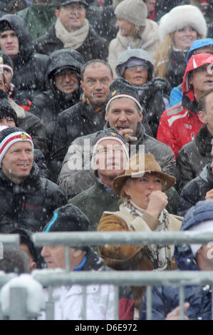 Österreichisch-US-Schauspieler und ehemalige US-Gouverneur von Kalifornien Arnold Schwarzenegger (C, vorne) und deutsche Schauspieler Ralf Moeller (C, oben) sehen die Männer bergab Hahnenkammrennen in Kitzbühel, Österreich, 21. Januar 2012. Das Elegendery-downhill-Rennen hat Alos ein Treffpunkt des Jetset. Foto: Felix Hoerhager Stockfoto