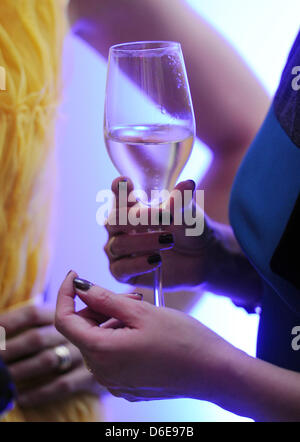 Ein weiblicher Gast mit einem Glas Champagner besucht die Gala Fashion Brunch im Rahmen der Berlin Fashion Week im Ellington Hotel in Berlin, Deutschland, 21. Februar 2012. Foto: Jens Kalaene Stockfoto