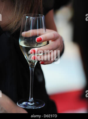 Ein weiblicher Gast mit einem Glas Champagner besucht die Gala Fashion Brunch im Rahmen der Berlin Fashion Week im Ellington Hotel in Berlin, Deutschland, 21. Februar 2012. Foto: Jens Kalaene Stockfoto