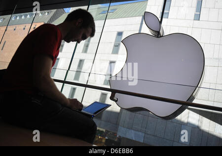 (Dpa Datei) - eine Archiv Bild, datiert 28. Mai 2010, zeigt einen Kunden sitzen mit seinem Notebook vor ein Logo des Computerherstellers Apple in einem Apple Store in München. Apple hat seine Ergebnisse für das 1. Quartal des aktuellen Geschäftsjahres am 24. Januar 2012 angekündigt. Foto: Andreas Gebert Stockfoto