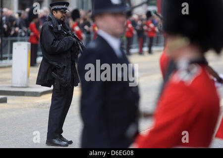 London, UK. 17. April 2013. Bewaffneter Polizist steht vor der Beerdigung von Margaret Thatcher. Im Anschluß-Markierungsfahne drapiert und auf einer Lafette montiert, bewegt sich der Sarg des ehemaligen britischen Premierministers Baronin Margaret Thatcher Sarg entlang Fleet Street in Richtung St. Pauls Kathedrale in London, England. Gewährt einem feierlichen Begräbnis mit militärischen Ehren, nicht gesehen, seit dem Tod von Winston Churchill im Jahre 1965, erwarten Familie und 2.000 VIP-Gäste (inkl. Queen Elizabeth) ihr Gefolge. Bildnachweis: Richard Baker/Alamy Live-Nachrichten Stockfoto