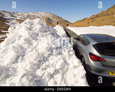 Massive Schneeverwehungen auf der Seite der Wrynose Passstrasse im Lake District, UK Stockfoto