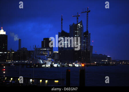 Die Baustelle der Elbphilharmonie und die umliegenden Gebäude der Hafencity sind abgebildet in der Abenddämmerung in Hamburg, Deutschland, 22. Januar 2012. Das zukünftige Wahrzeichen Hamburgs Steuerzahler 77 Millionen Euro Kosten und im Jahr 2010 öffnen sollte aber bisher 323,5 Millionen Euro ausgegeben worden und der möglichen Fertigstellungstermin im November 2014 eingerichtet wurde. Foto: Christian C Stockfoto