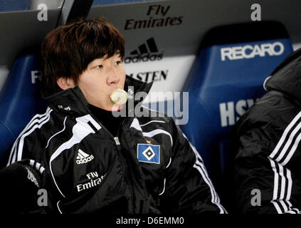 Hamburgs Heung Min Son sitzt auf der Bank und kaut Kaugummi während der Fußball-Bundesligaspiel zwischen dem Hamburger SV und Bayern München in der Imtech Arena in Hamburg, Deutschland, 4. Februar 2012. Foto: Christian Charisius Stockfoto