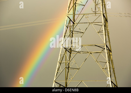 Ein Regenbogen über Pylonen Kernkraftwerk Wylfa auf Anglesey, Wales, UK verlassen. Stockfoto