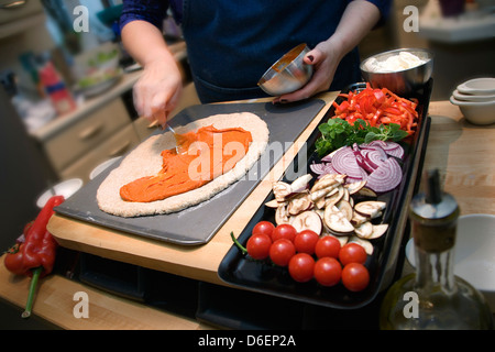 Verbreitung von Tomaten sauce auf Pizzateig / Schritt 11 Schuss Stockfoto