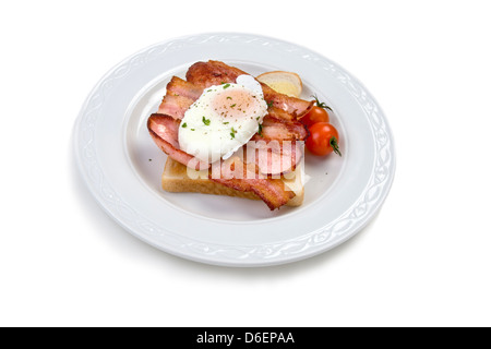 Pochiertes Ei auf weißen Toast mit Speck und Tomaten Stockfoto