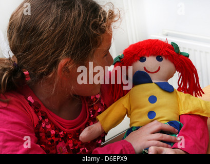 7 Jahre altes Mädchen hält Stofftier Puppe England Stockfoto