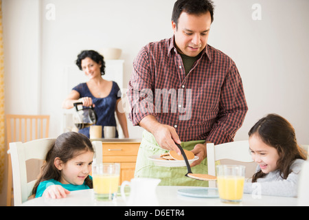 Vater, Töchter das Frühstück am Tisch serviert Stockfoto
