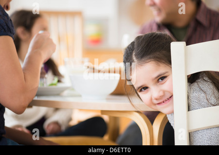 Lächelndes Mädchen am Tisch sitzen Stockfoto