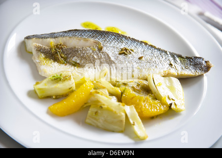 Braten Sie Wolfsbarsch mit gebratenem Fenchel und orange Segmente. Stockfoto