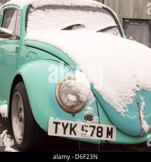 Ein altes blass-blauen VW Käfer Auto mit Schnee bedeckt. Stockfoto