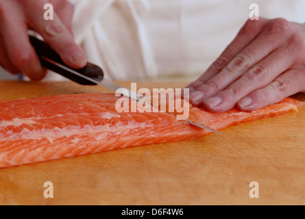 Schneiden-Schnitzel vom Lachsfilet Stockfoto