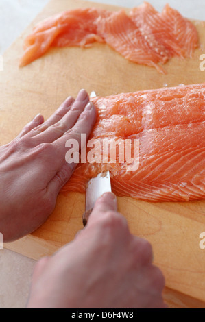 Schneiden-Schnitzel vom Lachsfilet Stockfoto