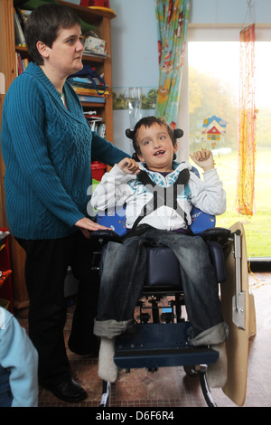 Sterup, Deutschland, ein Junge sitzt in einem Rollstuhl mit einer Kinderkrankenschwester Stockfoto