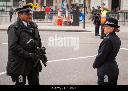 London Strand Baroness Margaret Thatcher Beerdigung bewaffneter Polizist mit Maschinengewehr chats Gespräche Polizistin wartet Parade cortege Stockfoto
