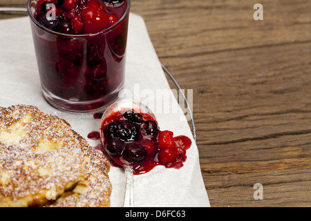 Detailansicht der hausgemachte Milch Reis Pfannkuchen mit süßen Beeren Obst Gelee vor der hölzernen Hintergrund Stockfoto