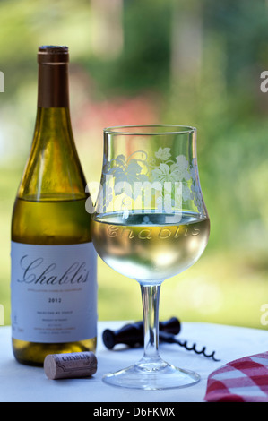 "Chablis" graviert Weingut tasting Glas Flasche Korken und Korkenzieher auf alfresco Terrasse Tisch in späten Nachmittagssonne Stockfoto