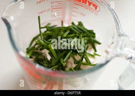 Schnittlauch und Creme Fraiche in einem Messgerät Krug Stockfoto