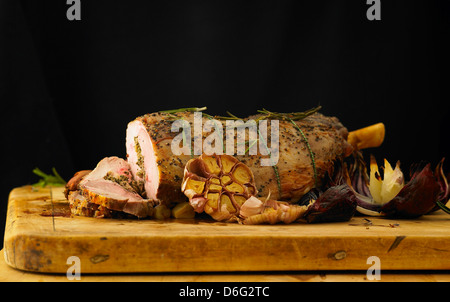 In Scheiben geschnittene gefüllte Lammkeule mit Knoblauch, Rosmarin und gebratene Zwiebeln Stockfoto