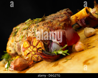 In Scheiben geschnittene gefüllte Lammkeule mit Knoblauch, Rosmarin und gebratene Zwiebeln Stockfoto