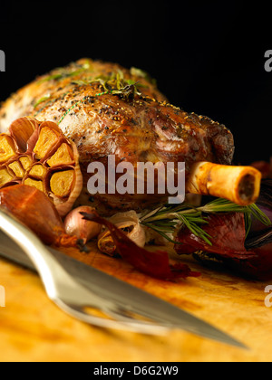 In Scheiben geschnittene gefüllte Lammkeule mit Knoblauch, Rosmarin und gebratene Zwiebeln Stockfoto