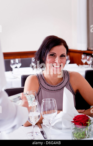 Mann und Frau zum Abendessen im Restaurant Kellner servieren Mineralwasser Stockfoto