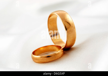 Goldene Hochzeit Ringe auf weißer Seide Stockfoto