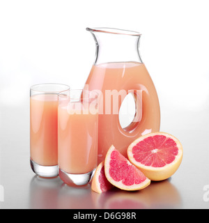 Glas Grapefruitsaft, zwei volle Gläser und geschnittene Grapefruit Stockfoto