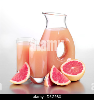 Glas Grapefruitsaft, zwei volle Gläser und geschnittene Grapefruit Stockfoto