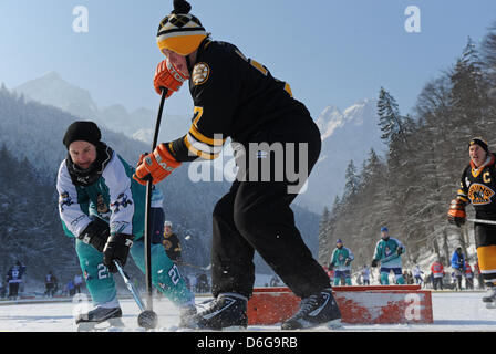 Zwei Teilnehmer des zweiten DEB Pond Hockey Cup kämpfen um den Puck auf dem zugefrorenen Riesser See in Garmisch-Partenkirchen, Deutschland, 12. Februar 2012. Amateure und professionelle Eishockey-Spieler nahmen Teil in das geschehen. Foto: Andreas Gebert Stockfoto