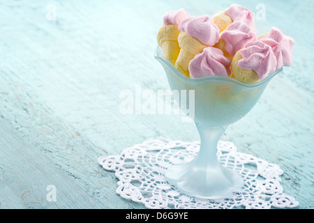 Zuckerhaltige rosa Marshmallows geformt wie Eis in einer Schüssel auf blauen Vintage Holz-Hintergrund Stockfoto