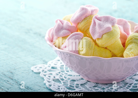 Zuckerhaltige rosa Marshmallows geformt wie Eis in einer Schüssel auf blauen Vintage Holz-Hintergrund Stockfoto