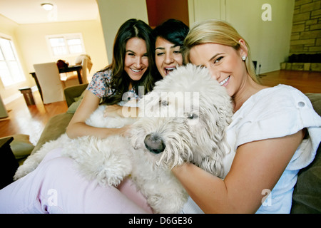 Frauen streicheln Hund in Küche Stockfoto