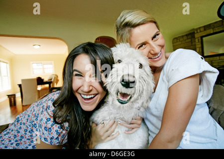 Frauen streicheln Hund in Küche Stockfoto