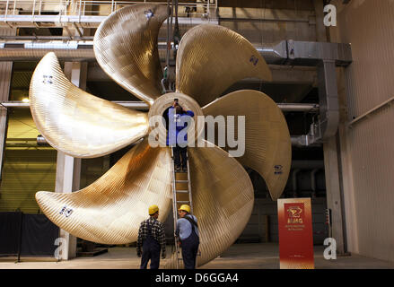 (DATEI) Ein Archivfoto vom 9. Dezember 2010 zeigt einen Mitarbeiter bei einem hundert Tonnen-Schiff Propeller bei Metallguss GmbH (MMG) in Waren, Deutschland, 16. Februar 2012. IG Metall Kueste (Sea Coast Region) berät über seine aktuellen Lohnforderungen auf einer Regionalkonferenz in Rostock auf Donnerstag, 16. Februar 2012. Der Vorstand der IG Metall will eine Lohnerhöhung von 6,5 Prozent. Foto: Bernd Wue Stockfoto
