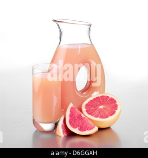 Krug mit rosa Grapefruit-Saft mit halbierten Grapefruit Stockfoto