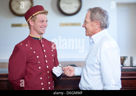 Älterer Mann Trinkgeld Hotelpage in lobby Stockfoto