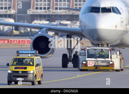 Eine so genannte Follow-Me Fahrzeug führt ein Flugzeug, einen Parkplatz auf dem Vorfeld des Flughafens in Frankfurt/Main, Deutschland, 20. Februar 2012 zu positionieren. Air Traffic Controller Union (GdF) entschieden, dass die Schürze Arbeitnehmer am größten Flughafen Germany s streiken wieder gehen. Rund 200 Montag Flüge wurden annulliert. Foto: BORIS ROESSLER Stockfoto