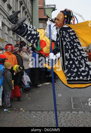 Eine so genannte Federahannes, einen Narren Charakter aus Rottweil, springt durch die Luft beim traditionellen Narren Sprung ("Narrensprung") in Rottweil, Deutschland, 20. Februar 2012. Der Narren-Sprung ist eine der traditionsreichsten Paraden des Schwäbisch-alemannischen Karnevals. Foto: PATRICK SEEEGR Stockfoto