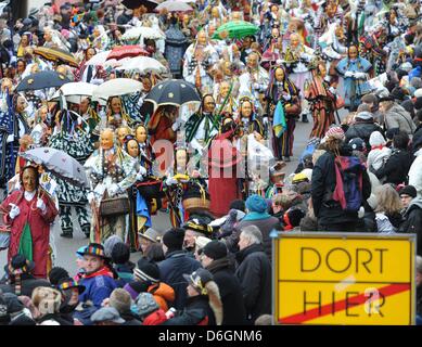 Eine so genannte Federahannes, Biss und Gschell, Narren Charaktere aus Rottweil, springen durch die Luft beim traditionellen Narren Sprung ("Narrensprung") in Rottweil, Deutschland, 20. Februar 2012. Der Narren-Sprung ist eine der traditionsreichsten Paraden des Schwäbisch-alemannischen Karnevals. Foto: PATRICK SEEEGR Stockfoto